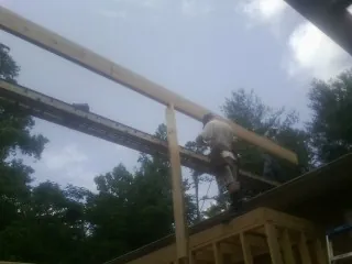 Carpenter setting a ridge beam over a new addition frame — Ice Dam Removal by Roofing Brothers in American Canyon