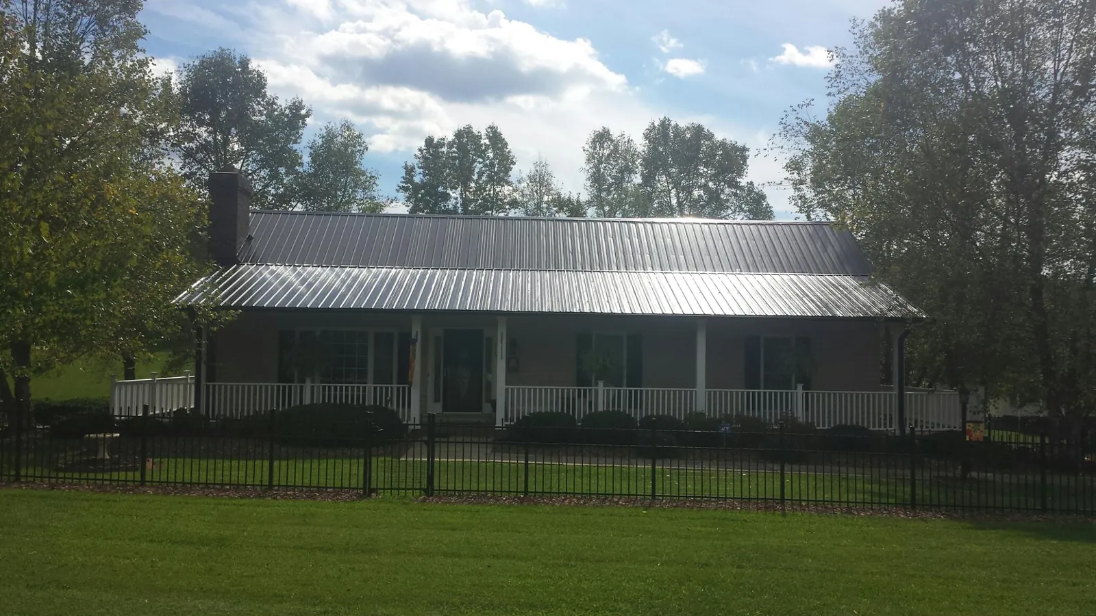 Gray metal roof on a brick ranch with a full width front porch — Gutter Guard Installation work by our crew in American Canyon